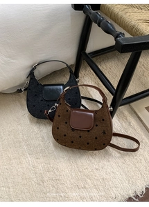 Détail de sacs hobo tissés à pois noir et marron posés sur un tapis blanc moelleux
