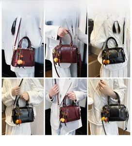 Detailed views of vintage Boston bag in burgundy and black with tassel charm on model