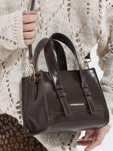 Minimalist dark brown glossy leather tote bag with gold hardware and wide handles
