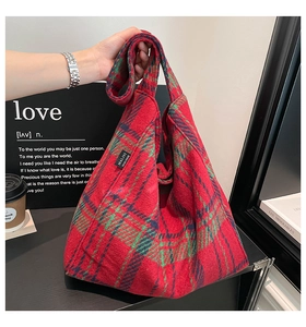 Detail shot of red and green plaid fabric tote bag with Malivi tag and textured wool finish
