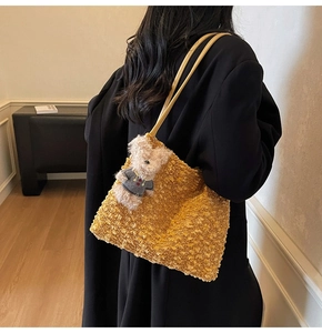 Détail du sac cabas en tweed jaune avec fines lanières et breloque ours en peluche