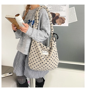 Gros plan d'un sac cabas en polaire pelucheux avec motifs floraux bleus et étiquette