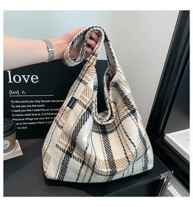 Detailed close-up of textured tartan wool fabric and brand label on a hobo tote bag