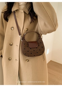 Détail du tissu à pois rétro et du rabat en cuir marron d'un sac bandoulière demi-lune