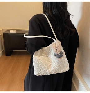 Détail du sac cabas blanc en fausse fourrure avec un joli pendentif ours marron