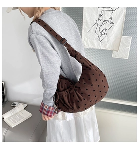 Détail d'un sac cabas marron à pois avec bandoulière réglable et texture en tissu souple