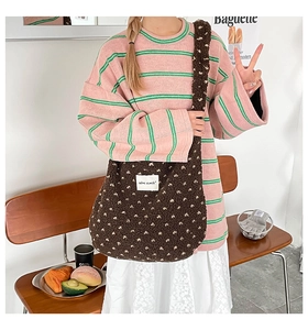Gros plan sur un sac bandoulière en peluche marron à motifs cœurs et tenue d'automne