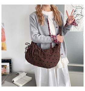 Detailed close-up of brown corduroy tote bag featuring black polka dots and side drawstring
