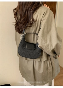Gros plan du sac hobo rétro à pois noirs sur un trench-coat avec rabat en cuir lisse