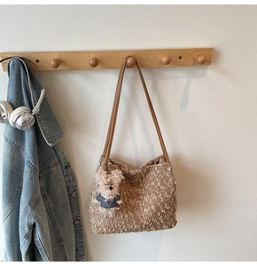 Détail du sac cabas en peluche marron avec anses en cuir et charm de chien mignon
