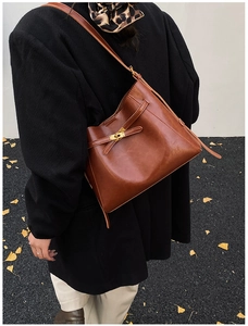 Détail du sac en cuir ciré marron vintage avec fermoir pivotant et sangle à boucle