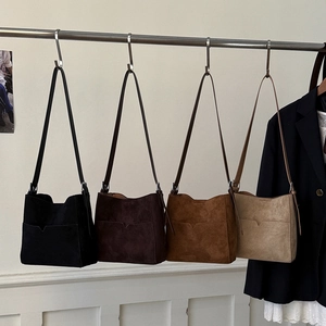 Detail of four vintage suede bucket bags in black coffee tan and beige colors