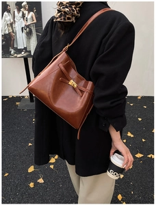 Détail du sac à bandoulière vintage marron foncé avec boucle en métal doré élégante
