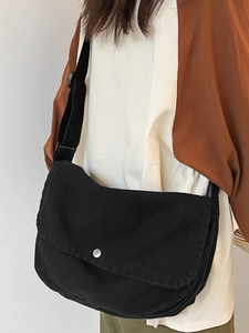 Minimalist black canvas messenger bag for women with wide adjustable shoulder strap
