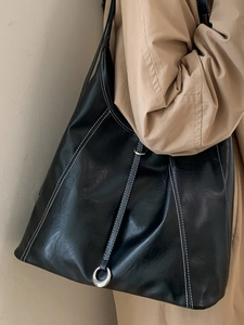 Minimalist black large capacity tote bag with white contrast stitching for daily commute