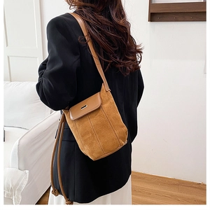 Detail of vintage brown suede and leather patchwork crossbody bag with gold buckle
