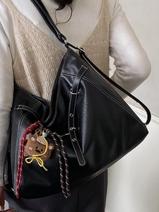 Large black leather tote bag with white contrast stitching and a cute bear charm