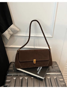 Dettaglio della borsa baguette vintage in pelle scamosciata marrone con chiusura dorata