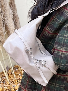 Minimalist beige large tote bag in glossy finish shown on model in autumn setting