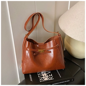 Détail du sac porté épaule marron vintage avec texture cirée brillante et fermoir doré