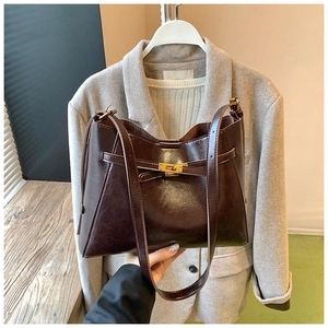 Détail du cabas vintage en cuir ciré marron avec fermoir tournant doré et bandoulière