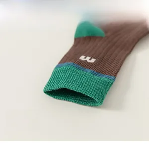 Detail of elastic ribbed cuffs on vintage green and brown knit socks for children