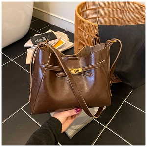 Détail du sac cabas en cuir marron foncé brillant avec fermoir doré élégant et chic