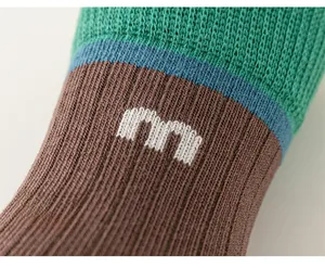 Close-up of retro knit cotton socks featuring letter m jacquard and ribbed elastic texture