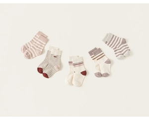 Flat lay of five pairs of cotton knit socks for children with stripes and m embroidery