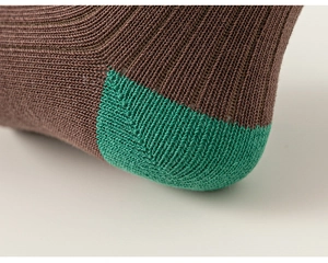 Detailed macro view of the two-tone ribbed knitting pattern and heel stitching on socks
