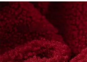 Close-up of soft burgundy sherpa fleece texture on a warm children's winter tracksuit