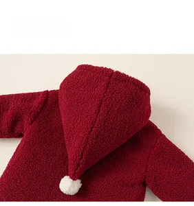 Detail view of red baby hooded fleece jacket with a white pom-pom on the pointed hood
