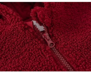 Detailed close-up of dark red fleece texture and durable resin zipper on girl jacket