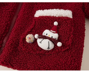 Detail of red fleece hoodie featuring a cute 3D snowman patch and pocket texture