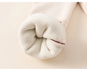 Detail of warm white sherpa fleece lining and red stitching on winter set for girls