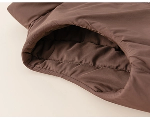 Détail des coutures et de la poche sur le gilet rembourré pour enfant marron foncé