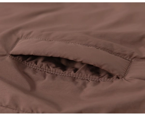 Gros plan sur la poche de la veste matelassée marron avec des coutures renforcées