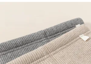 Detail of ribbed thermal leggings for girls showing elastic grey and beige knit texture