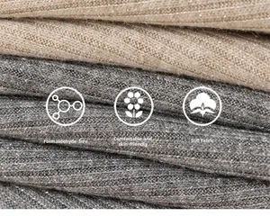 Close-up of soft beige and grey ribbed knit fabric with silver glitter threads for kids pants