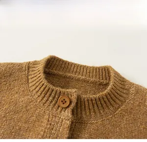 Detailed close-up of brown knit sweater neckline and round button on thick fabric