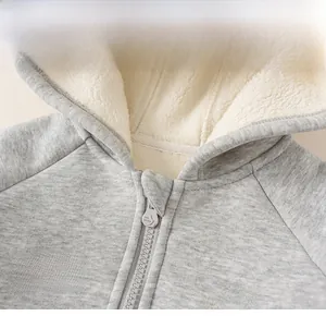 Detail of gray hooded jacket featuring warm white fleece lining and INS embroidery