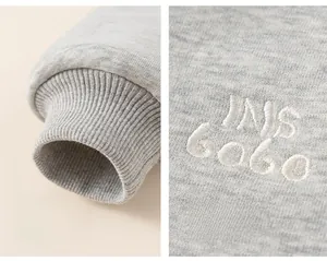 Detail of grey hoodie showing ribbed cuffs and INS GOBO letter embroidery craft