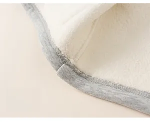 Detail of gray knit hoodie hem showing soft white fleece lining and durable stitching