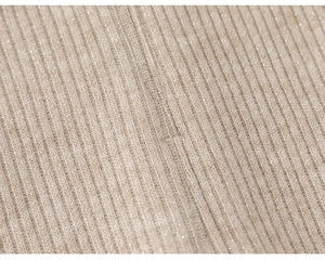 Macro shot of apricot ribbed knit fabric with subtle silver lurex glitter for girls' pants