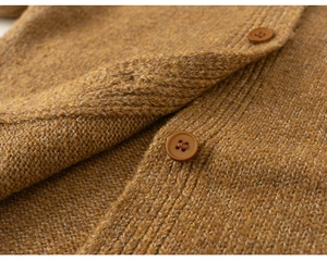 Detailed macro view of brown knit cardigan featuring textured grain stitch and brown buttons