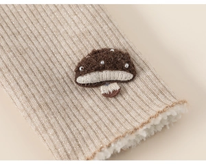 Detailed macro shot of girls warm leggings with mushroom embroidery and velvet lining