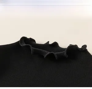 Detail of black knit top with ruffled lace collar and ribbed texture for kids