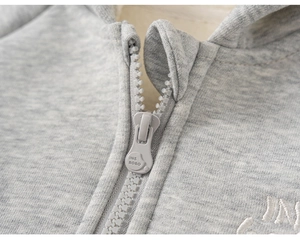 Detail of light gray hoodie showing warm fleece lining and branded plastic zipper head