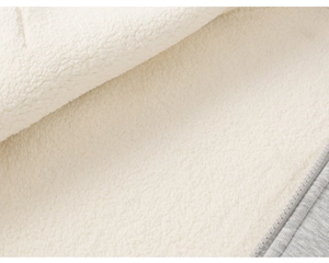 Close-up of thick white fleece lining and grey knit fabric with a matching zipper detail