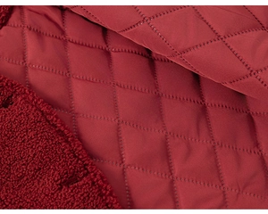 Detail of red quilted diamond fabric with warm sherpa fleece lining for winter outfits